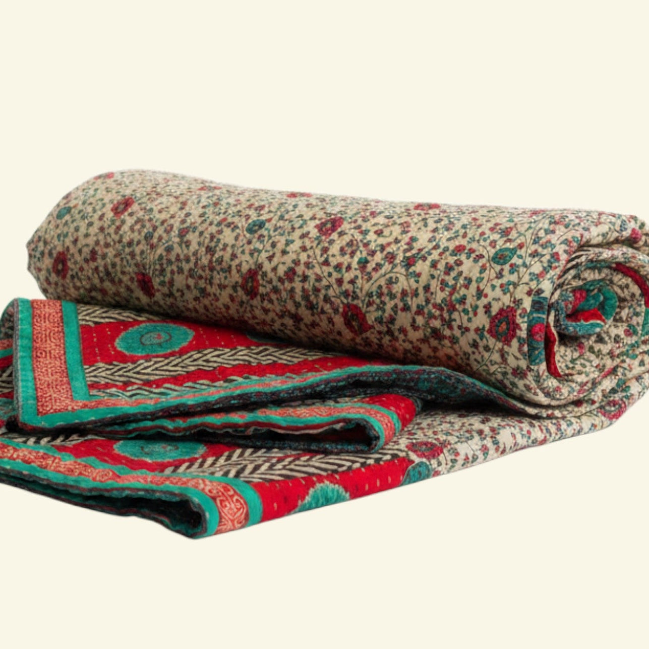 Rolled-up patterned blanket with red and green accents on a beige background