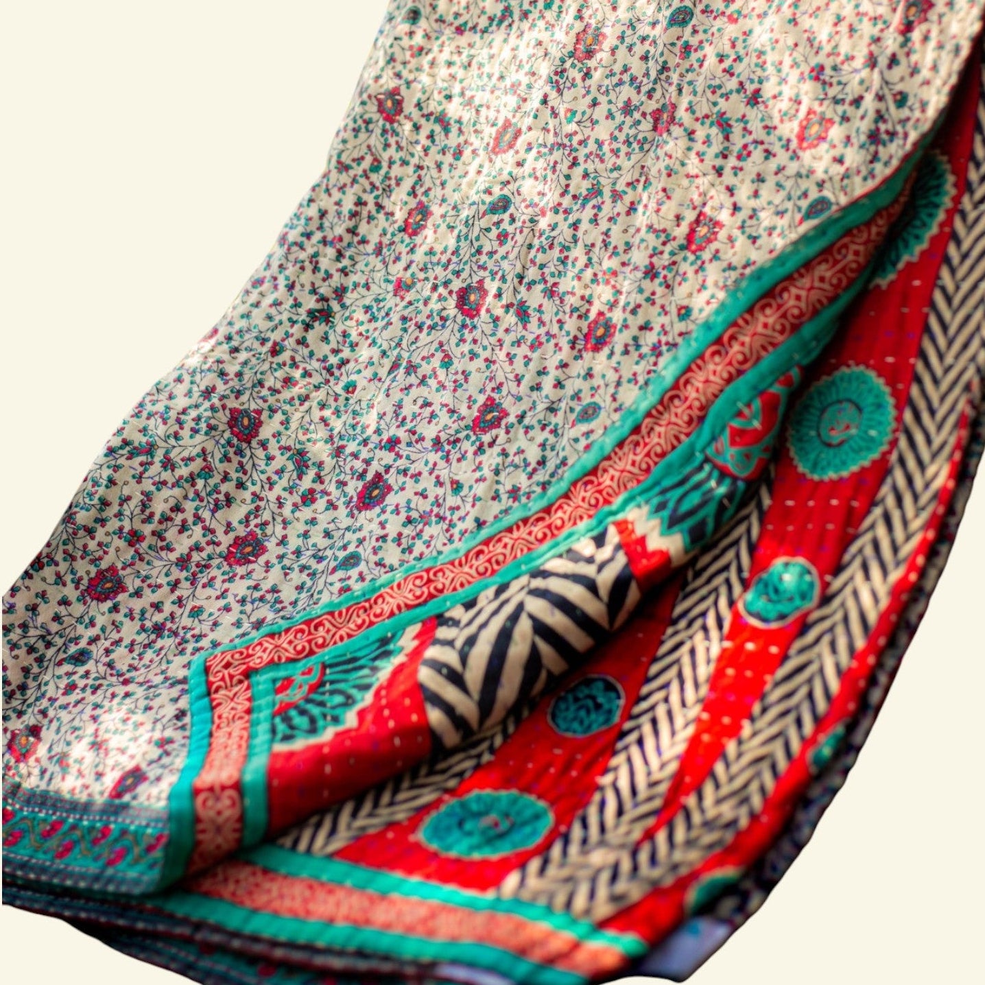 Folded fabric with floral and geometric patterns on a beige background