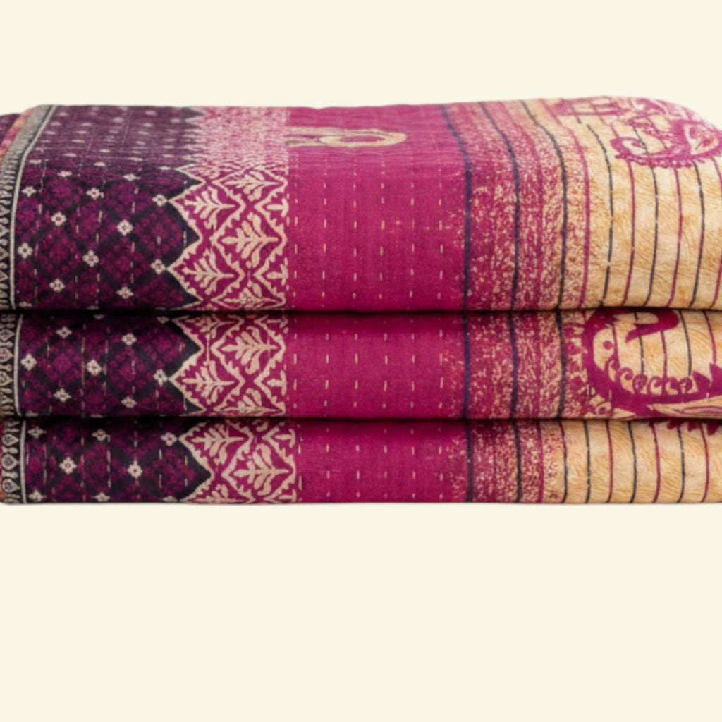 Stack of purple and beige patterned blankets on a white background