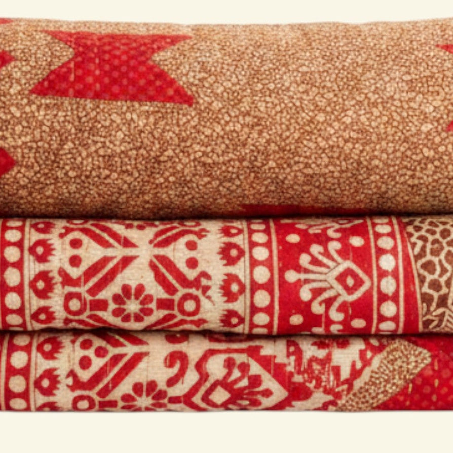 Stack of folded patterned towels in red and beige on a beige background