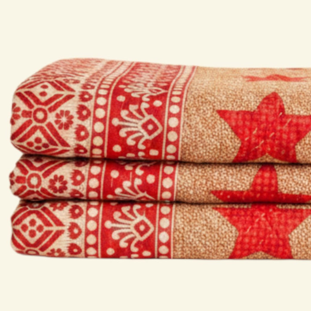 Stack of towels with red star patterns on a beige background