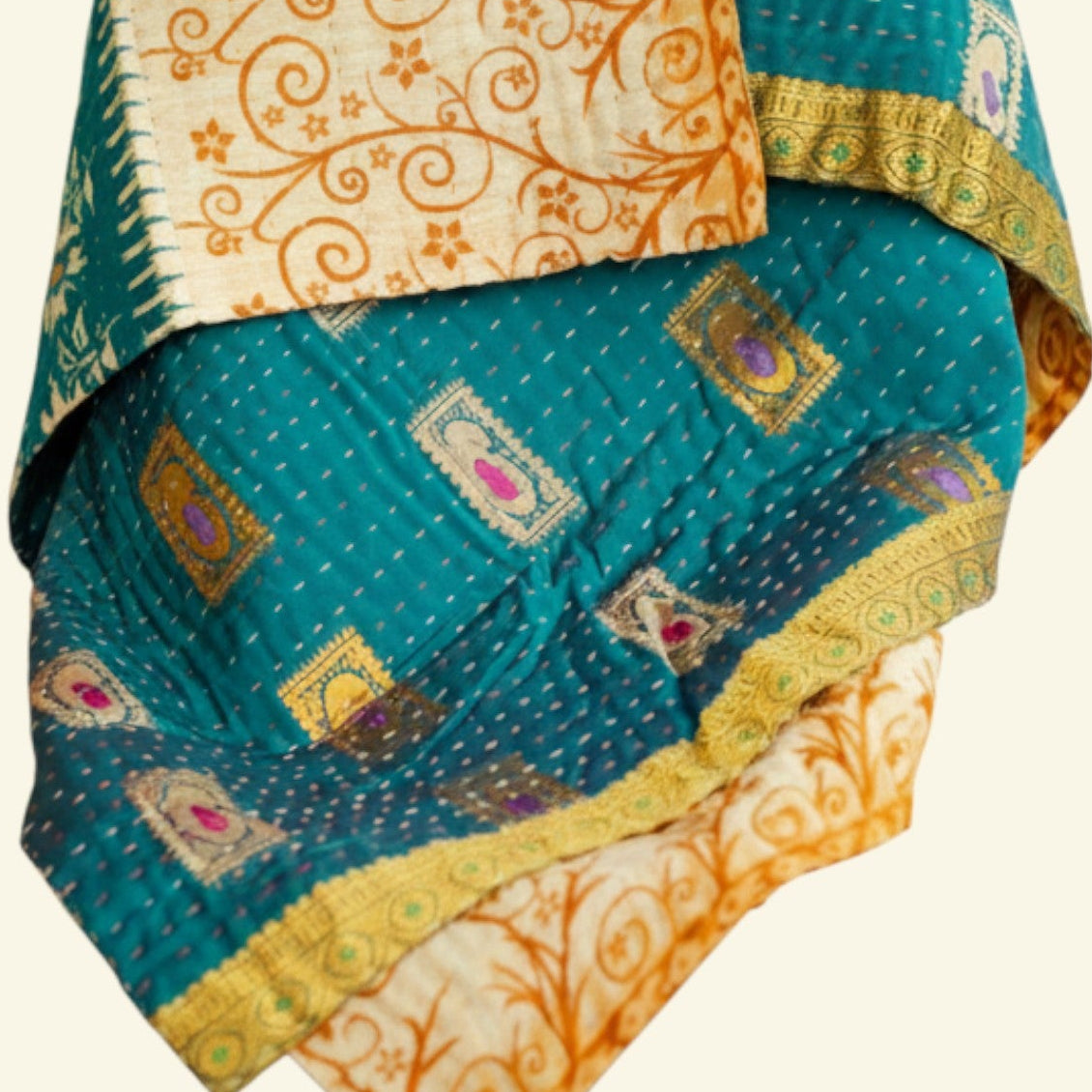 Traditional patterned fabric with teal, orange, and beige colors on a white background