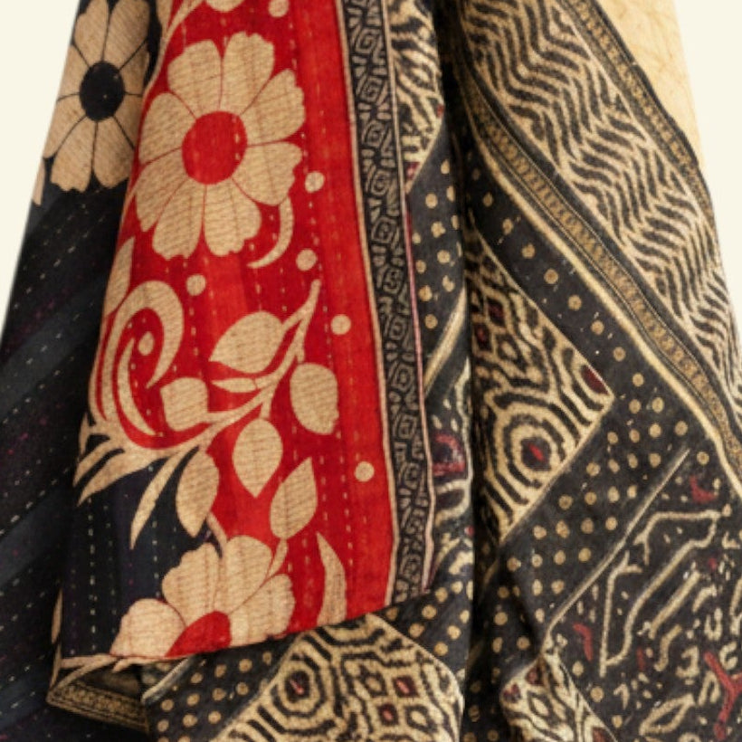 Patterned fabric with red, black, and gold colors on a white background