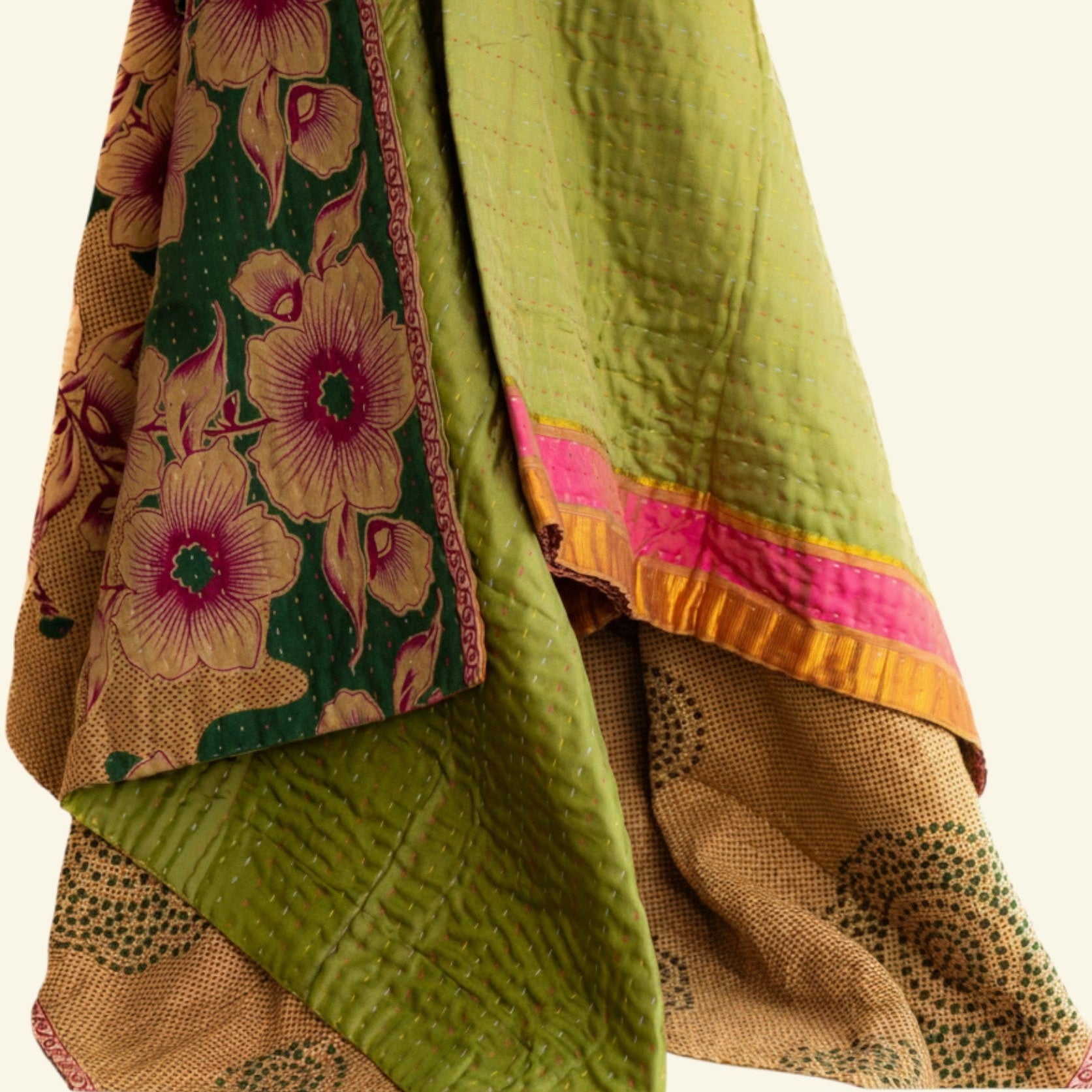 Traditional fabric with floral patterns in green, pink, and brown on a white background