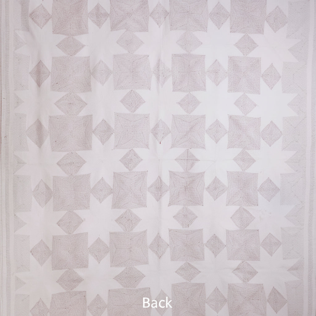Patterned quilt with geometric design on a white background