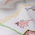 Close-up of a quilt with embroidered zebra designs on a white background