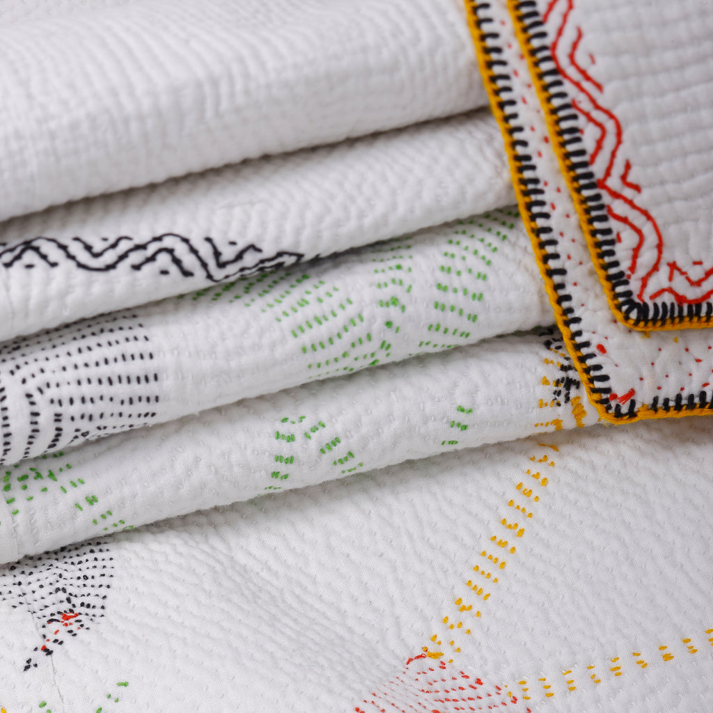 Stack of embroidered fabrics with intricate patterns