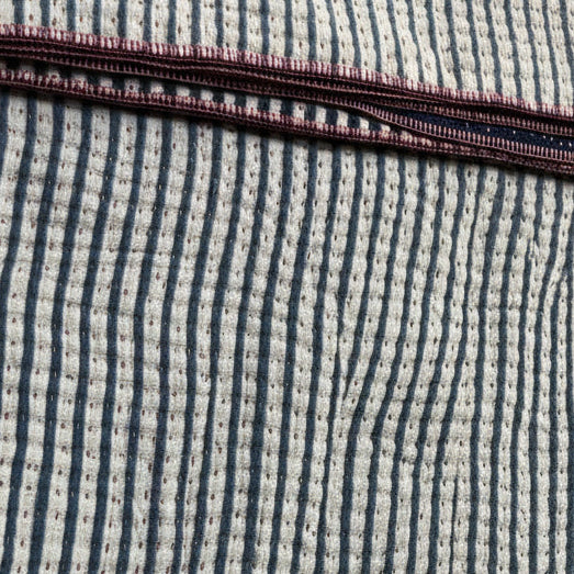 Close-up of a textured fabric with a ribbed pattern on a beige background